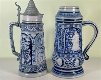 (2pc) METTLACH STEINS  |  A pair of large blue and grey Mettlach steins; one 2L lidded stein, the other slightly larger without a lid; both marked on bottom - h. 13 x dia. 6 in. (larger unlidded stein)
