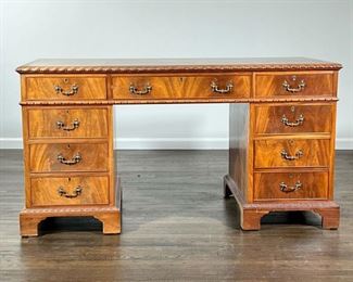 LIBRARY DESK  |   Natural finish, nicely figured wood library desk, of single piece construction with braided edge accents; having 9 drawers in total - l. 57 x w. 27 x h. 30 in.