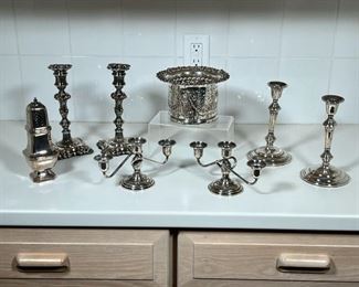 (8pc) SILVERPLATE ITEMS  |  Including an openwork basket, two pairs of candlesticks, a pair of three-arm candelabra, and a sugar caster - h. 9 in. (tallest)
