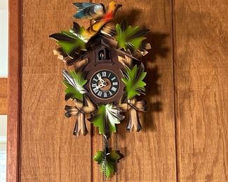 PAINTED CUCKOO CLOCK  |  20th century, small cuckoo clock with carved and painted leaves crested by a bird - l. 9.5 x w. 6 x h. 12.5 in. (box size)