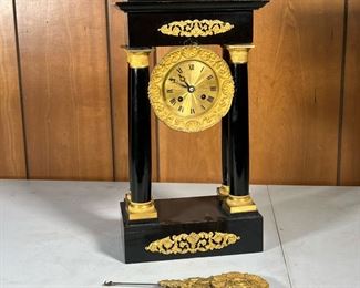 PALATIAL SHELF CLOCK  |  Open faced clock with Roman numerals, flanked by columns and painted black frame, gilt face and accents; pendulums featuring flower and swans - l. 9 x w. 5 x h. 16 in.
