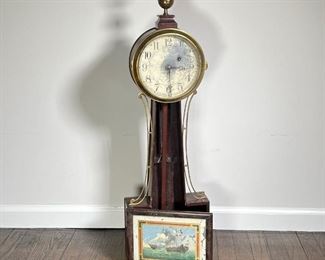 BANJO CLOCK  |  Banjo clock with reverse painted tablet of two ships at sea, no oculus cover, glass door covering face with patina / wear, cast brass sidearms and an eagle and ball finial - l. 10 x w. 4 x h. 36 in.