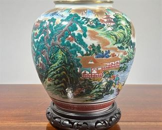 JAPANESE GILT ENAMEL VASE  |  On a conforming carved stand, vase/jar showing a mountainous riverside village scene, marked on the bottom - h. 11.5 x dia. 10 in. (overall)