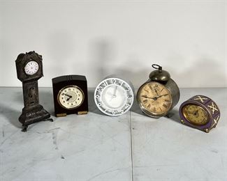 (5pc) LITTLE CLOCKS  |  Lot of small desk clocks, including a Knapp Bros vintage alarm clock, mini grandfather clock, Kienzle brass and enamel alarm clock, Seth Thomas 8 day clock, and a contemporary analog clock - h. 6 x dia. 4 in. (Knapp Bros. clock)