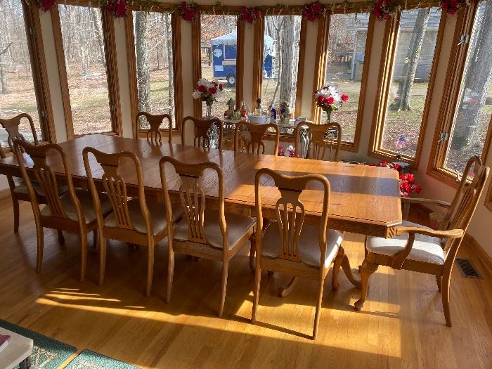 Large oak dining table shown with 4 leaves and 10 chairs