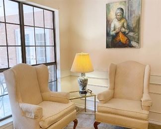 Cream-colored upholstered wingback chairs and MCM original painting of a woman sewing
