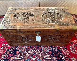 $400. Relief Carved Camphor Wood Chest. Ornately carved floral and village scenes with brass fittings throughout. Missing one brass piece. 35 x 17. X 16. Chinoiserie. 