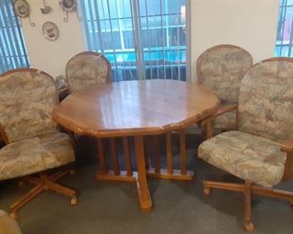 Table has a leaf that makes the table Oval. Four heavy Chairs on Casters
