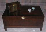 Walnut & Mahogany Trunk Cocktail Table with Rope inlay raised on a carved base of oriental influence