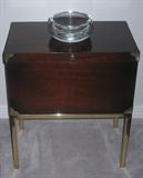 Old World Lane Mini Campaign Chest constructed of Mahogany veneers & hardwoods Raise on Brass Square Tube legs with brass mounts. (18 x 11 x 21H) Shown with large Crystal Ashtray