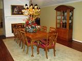Century Furniture Industries Dinning Room Suite. Solid Oak Construction. Table measures 76" x 44" and expands to 110" with 2 - 20" leaves and silver flatware drawers at each end. The inlaid oak table top with 4" ogee apron is raised on cabriole legs with carved acanthyus leaves and ball & claw feet. Seating for 10 with 8 side chairs & 2 arm chairs. Chairs have open fiddle fretwork backs with red ribbon shadow stripe upholster seats on cabriole legs with ball & claw feet.