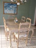 White Washed Solid wood Table with 6 Side Chairs. Chairs have hand carved ladder backs with Fruit pattern fabric upholstered seats set on handcarved Cabriole Legs.
