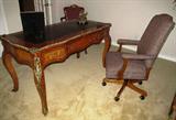 Louis XV French Style Bureau Plat Desk w / Leather Top and Brass Ormolu Trim shown with custom upholstered swivel walnut desk chair
Desk: Louis XV Style Bureau Plat is hand crafted in solis wood and veneered in Mahogany and Kingswood with a classic design. It features three drawers (center w/lock) and a black leather inset top with embossed gold leaf design. With heavy ormolu brass adds to the quality of this piece. Measures; 32"H x 58"W x 30"D