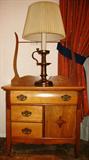 Antique Washstand with Towel Bar Back, Top Convex Front Drawer above two smaller drawers  and a single door enclosure.  Also shown is a Brass Candle Stick Lamp