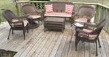 Brown Resin Wicker Patio Suite:  Settee, 2 Arm Chairs, 2 Swivel Rockers, Round Glass Top Table and a Chest/Trunk Style Coffee Table.  All Seating has Removable Zipper Cushions