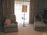 Master Bedroom sitting area with Baby blue Upholstered Swivel Rocker and Chaise. Glass top Floor Lamp Table