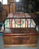 Antique Iron Bed with Antique Quilt and Lane Cedar Chest in the Fore ground.