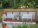 View of Back Deck with white benches and one of many birdbaths.