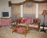 View of Den Showing Floral Wicker Sofa with Ratan/Glass Top Coffee Table, Round table w/TV and Pedestal End Tables.