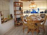 View of Breakfast Room showing Antique Oak Table with Wicker Chairs and Rattan Shelf. Glass & Pottery in the Background