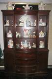 Large Mahogany Duncan phyfe style China Cabinet on Bracket feet. The upper Cabinet has a center door and two adjustable shelves. The lower cabinet hast 3 center drawers flanked by closed door cabinets. Cabinet is shwo here with a large collection of Fitz and Floyd