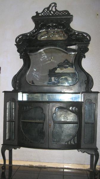  Victorian Etarge're on cabinet base raised on delicate pad feet Queen Anne legs, ornately carved  Carved scroll shelf supports. Cabinet has a bow front with curved glass double doors.  Top shelf has original brocade faric lining. Bevel crest shape center mirror and a smaller bevel mirror just below the crown. All appears to have original finish, mirrors & glass. The overall measurements are 89"H x 48"W x 16"D