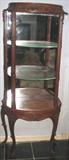 This is a small open Curio with mirrored back and glass shelves. Cabinet is ornately carvee and raised on delicate cabriole legs. Cabinet is totally dowel together and comes apart for travel