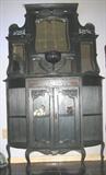 Victorian Etarge're on cabinet base with double glass panel doors flanked by corner shelves. The center bevel mirror has a shelf just below it with a carved ribbed pedestal support and bevel mirrors accenting it on each side. The upper cornice has a scollop apron and has turned spindle supports on each side and decorative shelves with bevel mirror behind the upper shelf and a sperate bevel mirror below each shelf. It is raised on pad feet Queen Anne legs. All finsh, mirrors and glass appear to be original. Measures 75"H x 48"W x 14"D
'