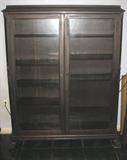Antique double door glass pane bookcase with adjustable shelves on carved claw feet. Appears to have original finish. 54"H x 43"W x 12"D