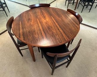 Stunning Danish Mid Century Dining Room Table and Four Chairs in overall very good condition with some light wear. 
The table measures 47" in diameter and comes with three leaves each measuring about 19.8"
Truly an absolutely gorgeous table! 