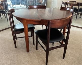 Stunning Danish Mid Century Dining Room Table and Four Chairs in overall very good condition with some light wear. 
The table measures 47" in diameter and comes with three leaves each measuring about 19.8"
Truly an absolutely gorgeous table! 