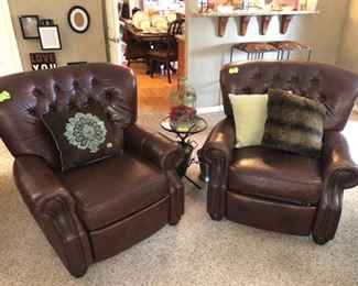 A pair of leather push-back recliners