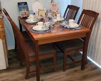 Teak dining table with extendable leaves (purchased from House of Denmark). Set of four dining chairs (sold separately).