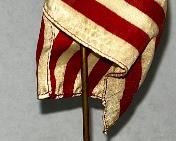 SMALL BRONZE MILITARY FIGURE HOLDING FLAG 