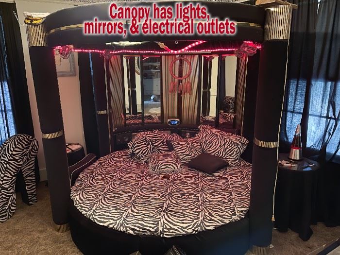 Circular bed with mirrored canopy with lights and electrical outlets. 
