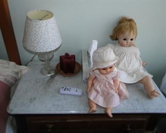 Dolls on marble top nightstand