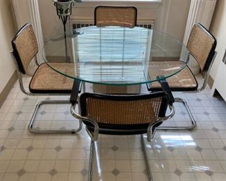 Glass topped round tabel with four cane chairs