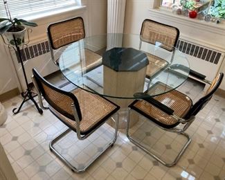 Glass topped round tabel with four cane chairs