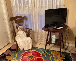 Antique pressed back rocker, occasional table with spindle legs, antique doll (not marked), TV, large floral rug (sold)