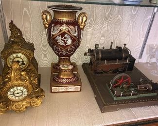 FULL VIEW OF A COUPLE OF ANTIQUE BRONZE CLOCKS, MEISSAN LAMP BASE AND SALESMAN SAMPLER OF STEAM ENGINE