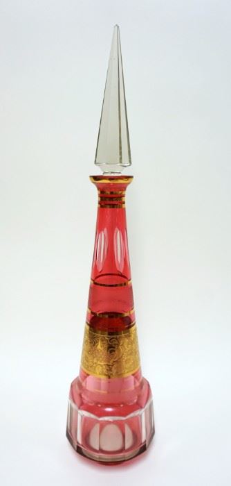 1001	LARGE CRANBERRY TO CLEAR DECANTOR W/PYRAMID STOPPER & GILT BANDING & TRIM, PANELED SIDES, CUT & POLISHED BOTTOM, APPROXIMATELY 26 IN HIGH
