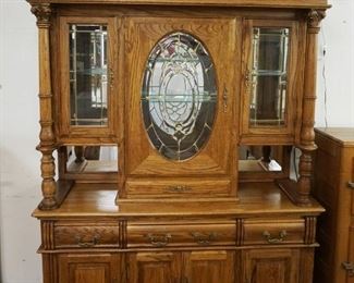 1178	CONTEMPORARY OAK SIDE BOARD WITH BEVELED PANELED GLASS DOORS, MIRROR BACK WITH INTERIOR LIGHTS HAVING CORINTHIAN COLUMNS AND CLAW FEET, APPROXIMATELY 65 IN X 20 IN X 91 IN H
