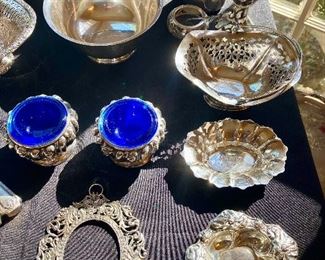# 73). Wallace Sterling baby cup                                           
# 76) bon-bon/nut dish 
# 74).  Sterling Revere bowl 31                                                     # 75)  figurative sterling frame front                         
A pair of silver plate master salts with cobalt inserts 
