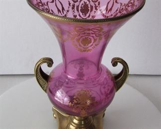 Lot 12   Early 20th C. French glass and bronze Mantle Urn, lavender w/gilt decorations, all bronze top ring, handles and base w/ball feet.  13 1/2" h. x 7 1/2" dia.  Condition:  Minor wear to the gilt decorations.