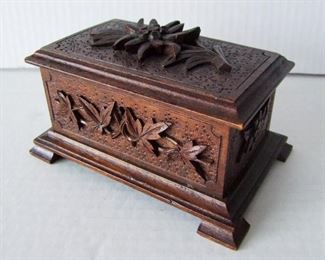 Lot 16   C/1880 German Walnut Jewel Box. Leaf and flower carved exterior, padded silk lined interior, 6 3/4" x 4 1/2" x 3 3/4", lockable (no key).  Condition:  Varnish is dark on lid, minor wear on corners and petals on lid, no other damage found.  