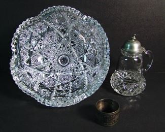 Lot 38   3 Piece Victorian group includes: C/1890 8" dia. Brilliant Period cut crystal bowl, 3 3/4" h. - C/1880 Pressed covered Syrup w/twisted pontil base, 5 1/2" h. - Victorian Silver-plate napkin ring, 1 3/4" dia.  Condition:  No damage found to bowl or syrup, napkin ring is worn and tarnished.  