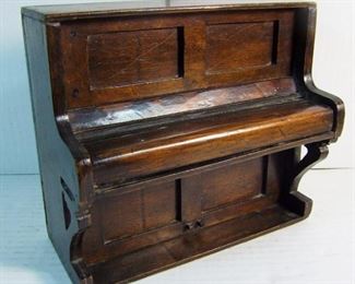 Lot 39   C/1915 Wooden Upright Piano Bank, slotted back, working cover over keys, 9" x 4 1/2" x 8" h., sliding wood piece at back base to release coins inside.  Condition:  Moderate wear, keys are worn.  These banks were issued by Piano Stores to save up enough quarters to make a down payment for a piano.   