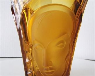 Lot 51   1934 Art Deco Amber glass Vase by Walther & Sohne Co., Germany with 3 faces in relief - Mother, Father and Child's faces.  Tapered form, polished base, 7 1/4" h. x 6" dia.  Condition:  One tiny inner rim flake, fire polished tiny bubble in outside edge (occurred  during manufacturing) minor wear on base.