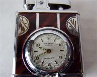 Lot 55   C/1955 "Windsor" Watch/Lighter, unused in original box w/sleeve and guarantee.  Swiss made, "Time Light" model made by the Windsor Watch Corp. with "Deluxe" stamped on bottom, case measures 3"x3 3/4" x 1"h.  Condition:  Mint, unused.