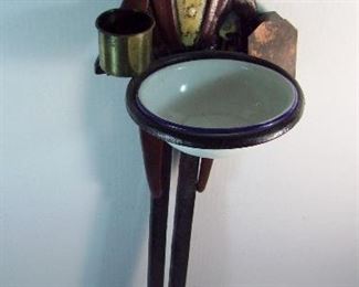 Lot 75   Vintage Cast Iron Black Butler Smoking Stand, includes porcelain ash bowl (cigars) plus brass match holder and burnt match cup, 33 1/4" h. with 7 1/2" sq. base.  Condition:  Wear from use, some paint loss on base.    